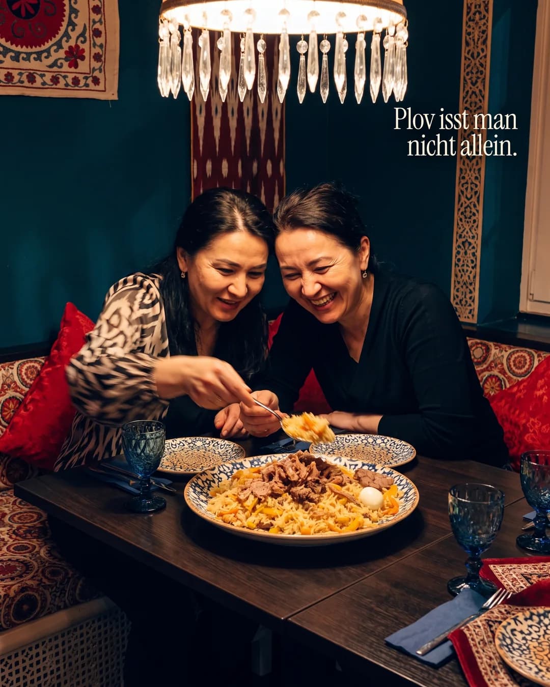 Zwei Frauen essen gemeinsam Plov, Text: Plov isst man nicht allein.